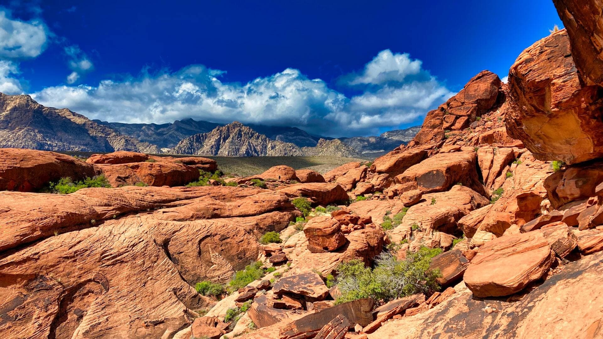 Red Aztec sandstone formations under a blue sky