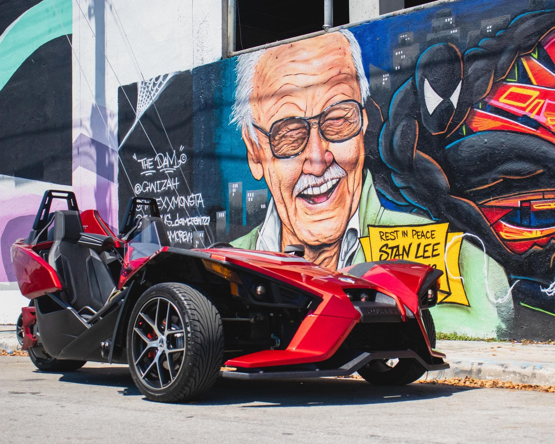 Red Polaris Slingshot parked in front of a large Las Vegas mural